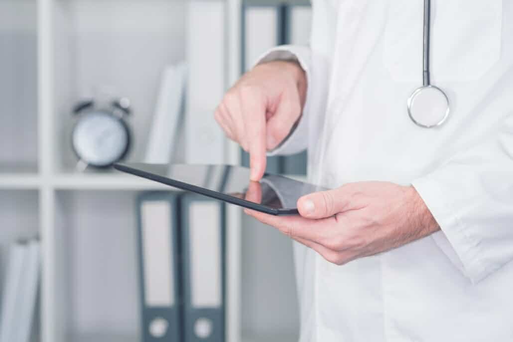 Modern technology in healthcare and medicine. Male doctor using digital tablet computer in office.