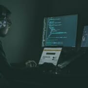 Cybersecurity Trends Man with headphones on on computer writing code