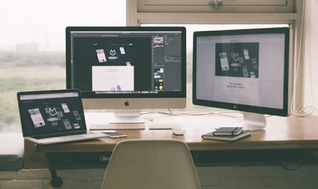 Two monitors and a laptop to represent outsourced or managed IT for cost efficient business