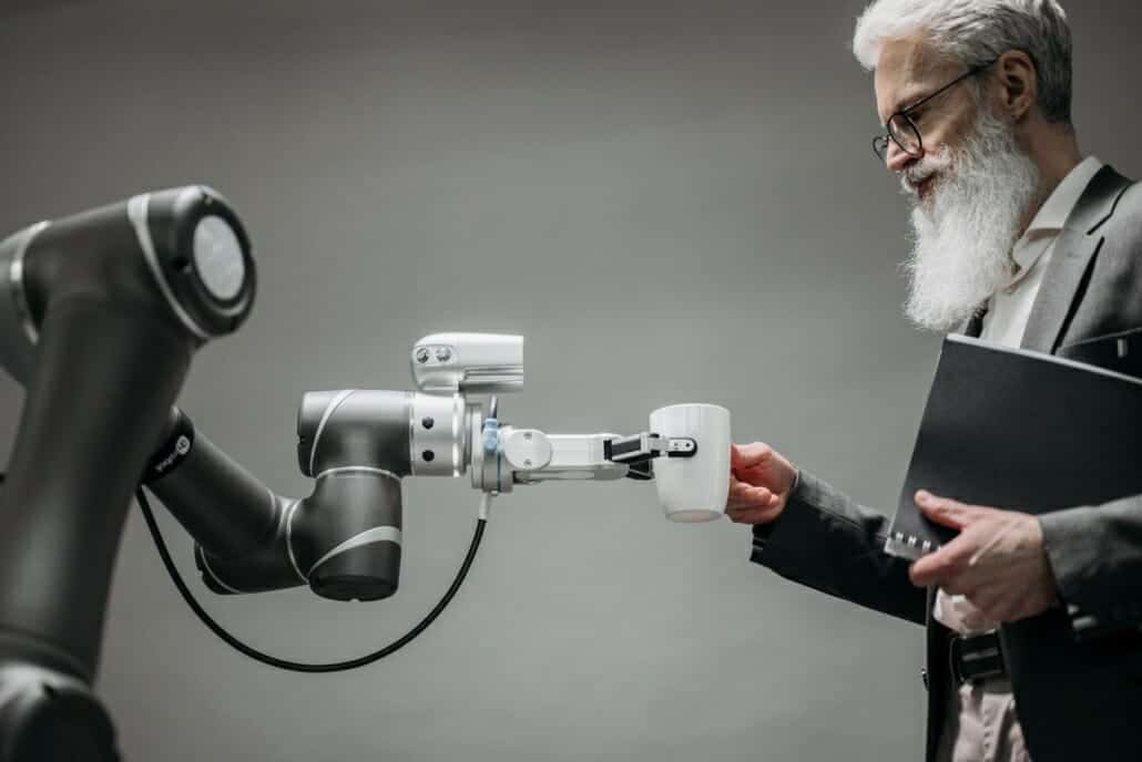 A person being handed a cup of coffee from a robot powered by artificial intelligence.