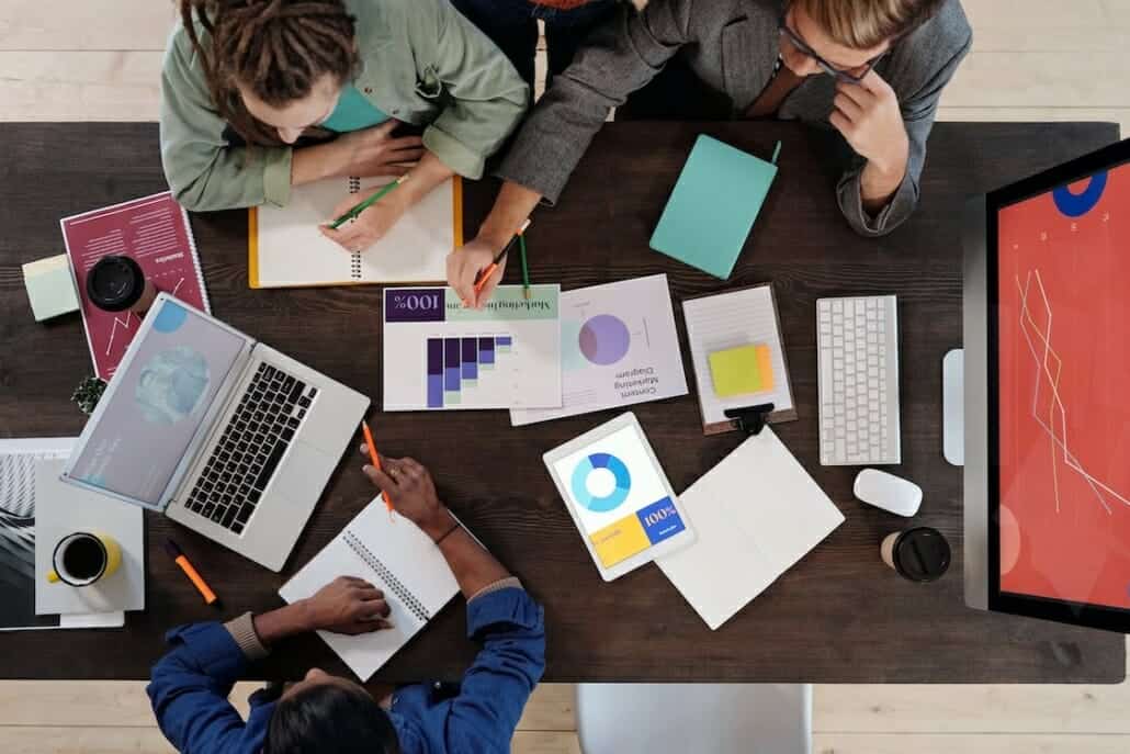 People huddled around an office table after an IT emergency wishing they had a preplan.