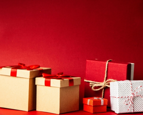 Gold, white, and red presents in front of a red background