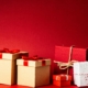 Gold, white, and red presents in front of a red background