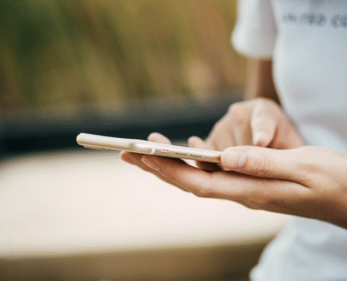 Close-up of a person holding a smartphone and typing with one hand.