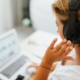 Person wearing a headset at a laptop, representing call forwarding and modern business phone support