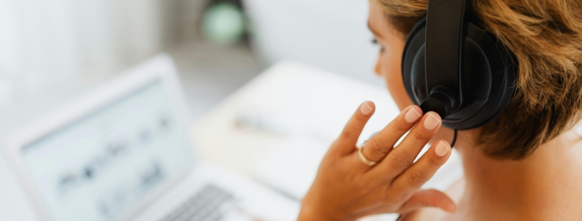 Person wearing a headset at a laptop, representing call forwarding and modern business phone support