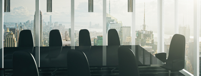 Modern executive conference room with floor-to-ceiling windows overlooking a city skyline, representing strategic technology leadership and business growth.