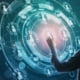 Hooded figure interacting with a glowing digital interface displaying connected user profiles, email icons, and streams of binary code.