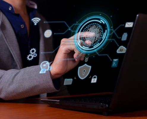 A business professional uses a fingerprint scanner on a digital interface beside a laptop, surrounded by cybersecurity, cloud, Wi-Fi, AI, and data icons.