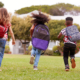 Children wearing backpacks run toward school, representing the back-to-school season and a cybersecurity reset for Richmond businesses.